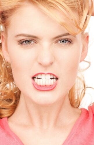 Mujer joven enseñando sus dientes listos para ser enderezados con clear braces 