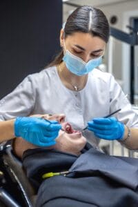 Dentista de McLeod Dental realizando tratamiento de relleno dental en paciente latino