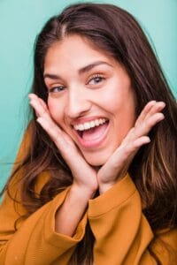 Mujer adulta luciendo sonrisa perfecta después de tratamiento de brackets invisibles en McLeod Dental