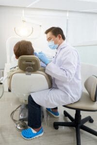 Dentista de McLeod Dental explicando qué cuidados debe tener  el paciente ahora que ya tiene sus prótesis dentales