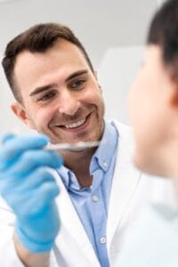 Dentista de McLeod Dental comprobando por primera vez la dentadura de paciente para comenzar tratamiento de Diseño de sonrisa