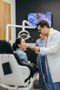 Dentista de McLeod Dental comprobando cómo quedó el empaste dental en paciente después de haber terminado el procedimiento