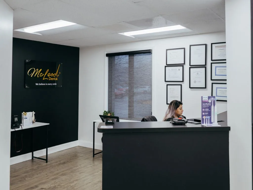 Recepcionista de McLeod Dental atendiendo a paciente latino con cita previa