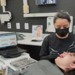 Dentista evaluando las encías de una paciente antes de realizar una limpieza dental profunda