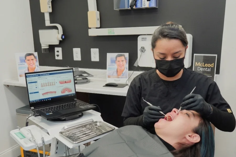 Dentista evaluando las encías de una paciente antes de realizar una limpieza dental profunda