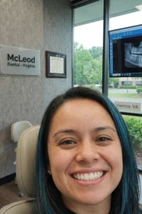 Paciente mostrando una sonrisa saludable después de un tratamiento de limpieza dental profunda