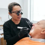 Dentista revisando un empaste antiguo para comprobar si necesita ser reemplazado.
