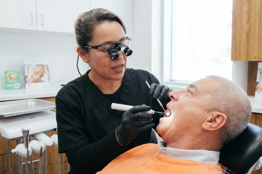 Dentista revisando un empaste antiguo para comprobar si necesita ser reemplazado.