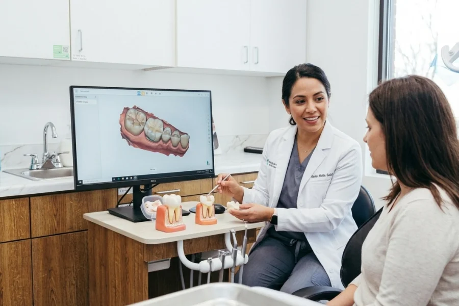 Dentista mostrando a un paciente las diferencias entre un Inlay de porcelana y una restauración con composite dental en una clínica de Virginia