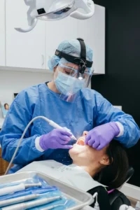 Higienista dental realizando una limpieza periodontal para eliminar el sarro bajo las encías en una clínica dental de Estados Unidos
