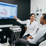 Dentista explicando el coste de una prótesis parcial removible a un paciente en una clínica dental moderna de Virginia