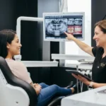 Dentista explicando a una paciente hispana si duele una limpieza dental profunda en una clínica dental moderna de Virginia
