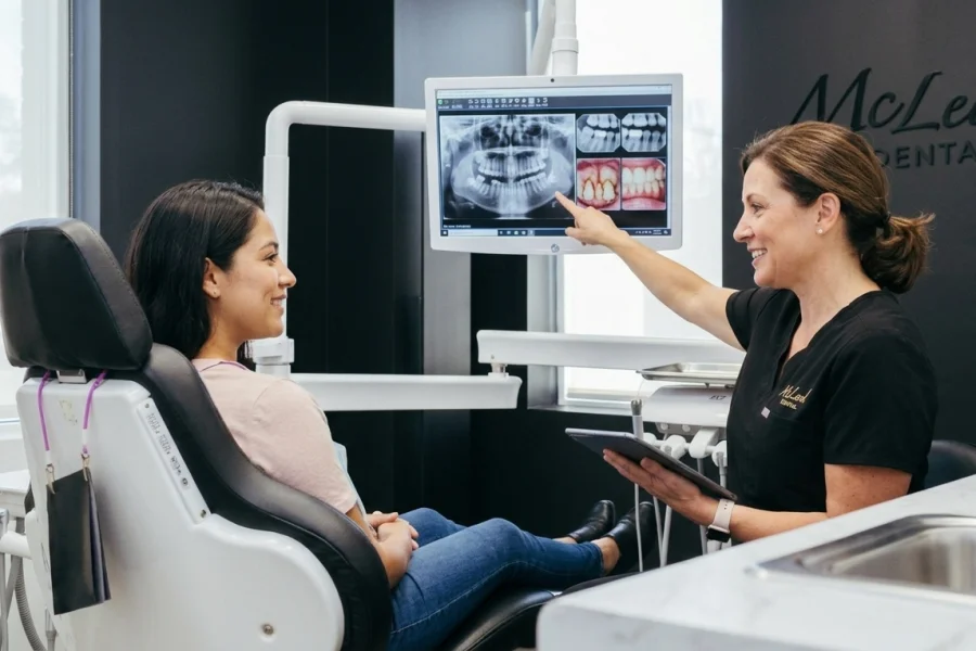 Dentista explicando a una paciente hispana si duele una limpieza dental profunda en una clínica dental moderna de Virginia