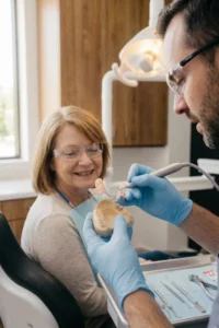 Dentista realizando un ajuste profesional de una prótesis removible.
