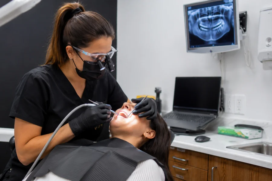 Dentista realizando una limpieza dental profunda para tratar las encías