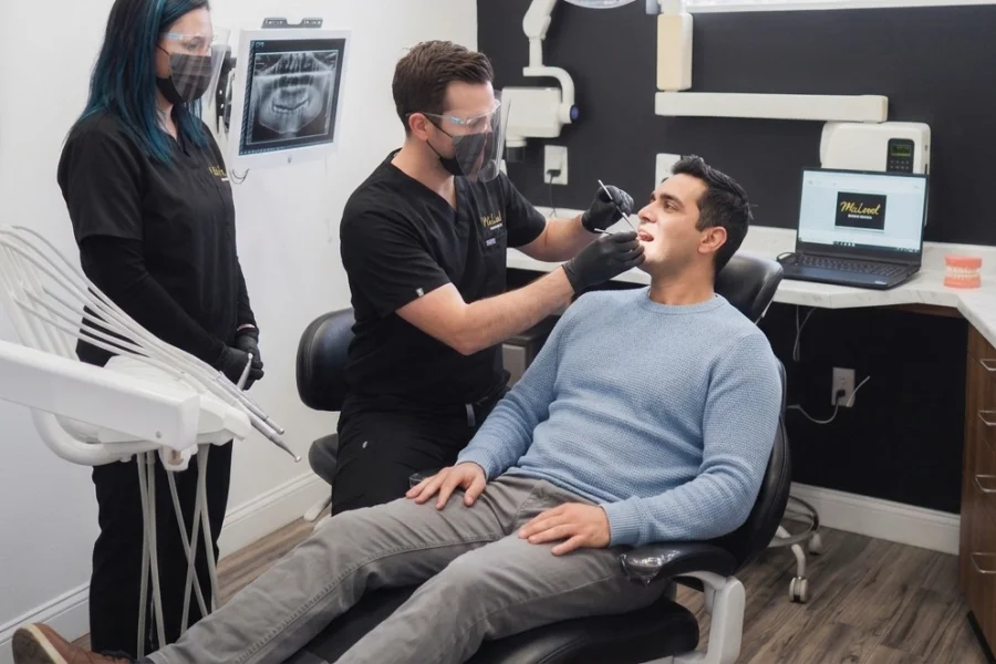 Dentista realizando una revisión dental preventiva a un paciente