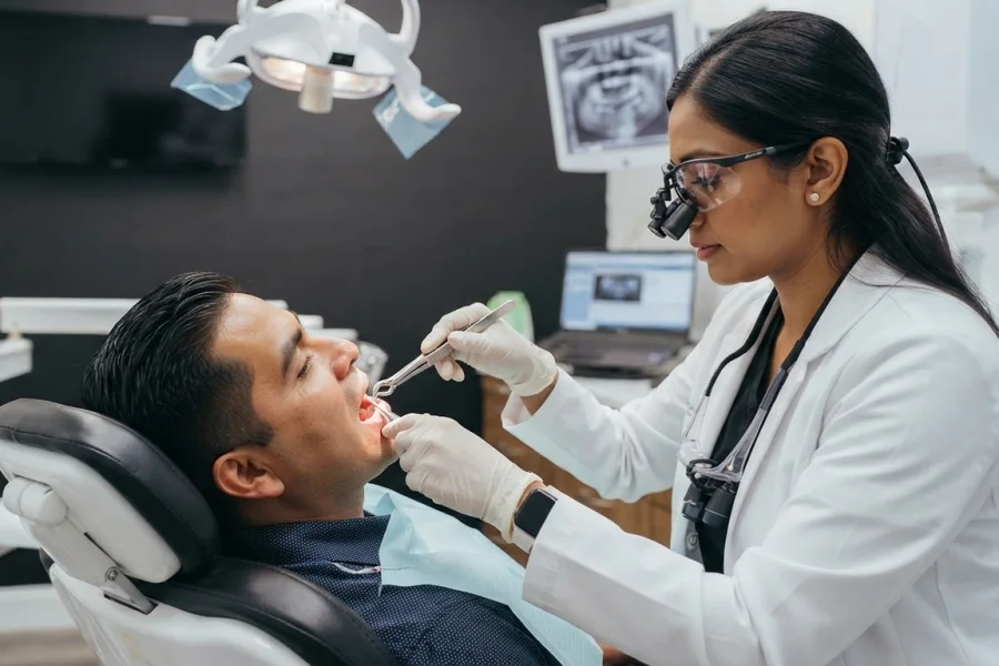 Dentista realizando una extracción dental con anestesia local