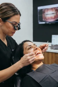 Dentista evaluando los dientes de una paciente antes de un tratamiento estético